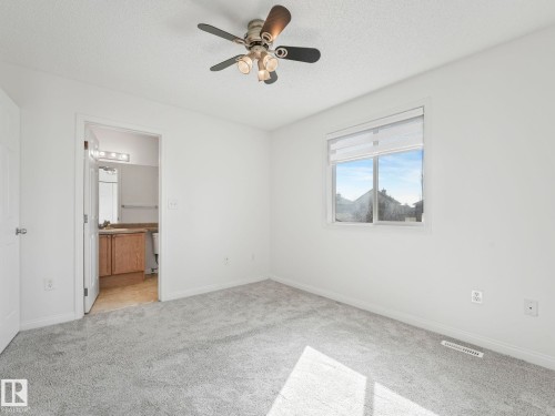 This room features light gray carpet flooring, white walls, and a ceiling fan with integrated lighting - 675 Mcallister Loop, Edmonton, AB - Indoor Photo Showing Other Room