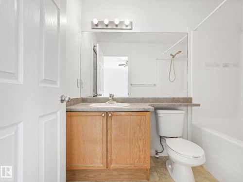 The bathroom features a light wood vanity with a built-in sink, a large wall-mounted mirror, and a toilet - 675 Mcallister Loop, Edmonton, AB - Indoor Photo Showing Bathroom