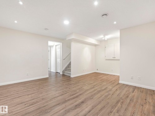 This open space features light wood-look flooring, bright white walls, and recessed lighting - 675 Mcallister Loop, Edmonton, AB - Indoor Photo Showing Other Room