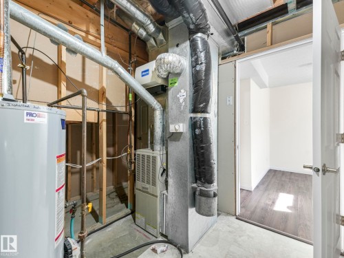 The property features a water heater and furnace, with exposed ductwork and framing - 675 Mcallister Loop, Edmonton, AB - Indoor Photo Showing Basement
