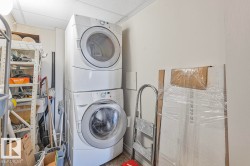 This utility area features a stacked white washer and dryer unit, providing convenient laundry facilities - 