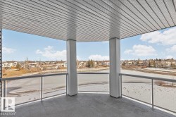 The property features a balcony with a gray floor and a glass railing, offering expansive views of the lake and surrounding homes - 
