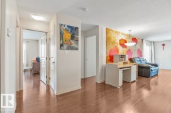 The property features hardwood floors throughout the main living areas, white walls, and a decorative accent wall with a floral design - 
