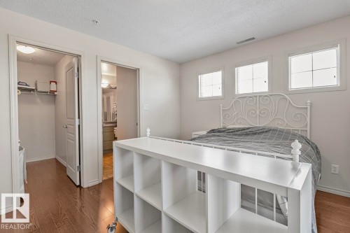 The room features hardwood floors and three windows providing natural light - 225 16035 132 Street, Edmonton, AB - Indoor