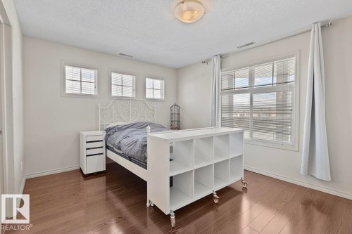 This room features polished hardwood flooring, white walls, and a ceiling light fixture - 225 16035 132 Street, Edmonton, AB - Indoor Photo Showing Bedroom