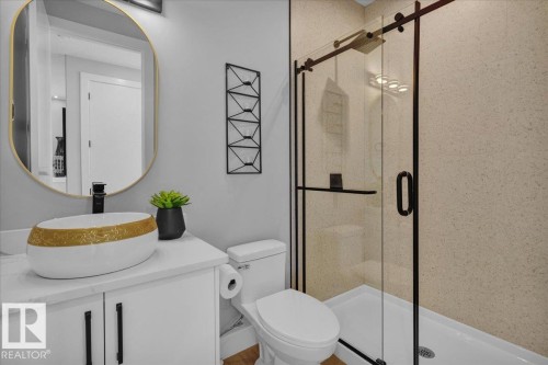 This bathroom features a contemporary vanity with a vessel sink and a gold-framed mirror - 207 Starling, Fort Saskatchewan, AB - Indoor Photo Showing Bathroom