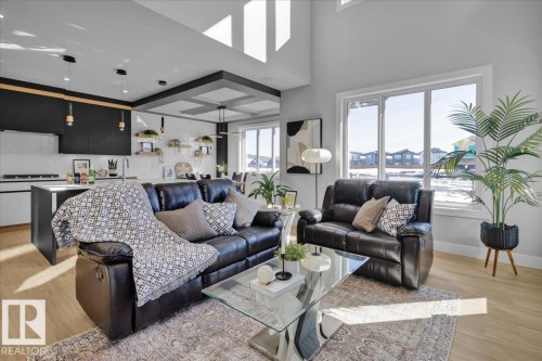 The property features an open-concept living area with high ceilings and large windows providing natural light - 207 Starling, Fort Saskatchewan, AB - Indoor Photo Showing Living Room