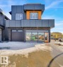 The property features a modern exterior with dark gray and wood-look cladding, an integrated garage, and a prominent orange front door - 207 Starling, Fort Saskatchewan, AB  - Outdoor 