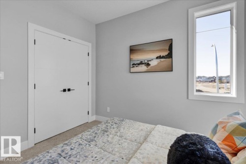 The room features light gray walls, a window providing natural light, and carpeted flooring - 207 Starling, Fort Saskatchewan, AB - Indoor