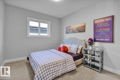 This room features light gray walls, a window with white trim, and light-colored carpeting - 207 Starling, Fort Saskatchewan, AB - Indoor Photo Showing Bedroom