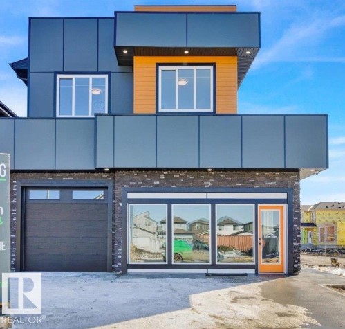 The property features a contemporary architectural style with dark grey paneling and wood-look accents - 207 Starling, Fort Saskatchewan, AB - Outdoor