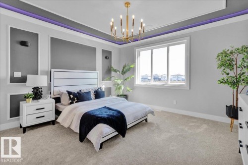 This room features a tray ceiling with accent lighting, a large window providing natural light, and plush carpet flooring - 207 Starling, Fort Saskatchewan, AB - Indoor Photo Showing Bedroom