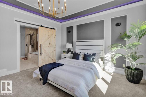 This property features recessed lighting with accent color, a modern chandelier, and a barn door leading to a bathroom with a shower and soaking tub - 207 Starling, Fort Saskatchewan, AB - Indoor Photo Showing Bedroom