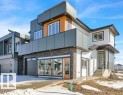 The property features a modern exterior with a mix of white siding, dark grey panels, and stone accents - 207 Starling, Fort Saskatchewan, AB  - Outdoor 