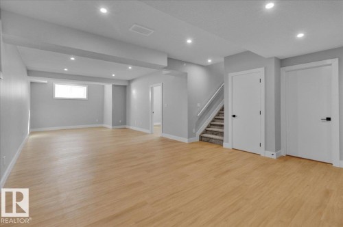 Expansive open area featuring light wood flooring, recessed lighting, and a neutral grey color scheme - 207 Starling, Fort Saskatchewan, AB - Indoor