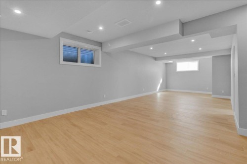The expansive room features light-toned wood flooring, light grey walls, and recessed lighting - 207 Starling, Fort Saskatchewan, AB - Indoor