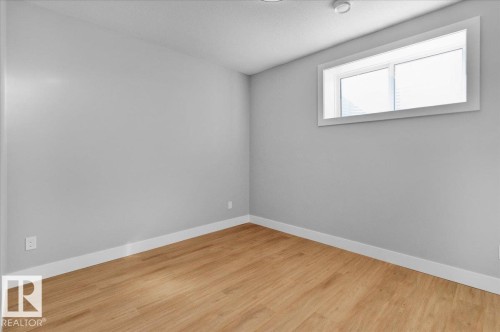 This room features light-colored walls, light wood flooring, and a window providing natural light - 207 Starling, Fort Saskatchewan, AB - Indoor Photo Showing Other Room