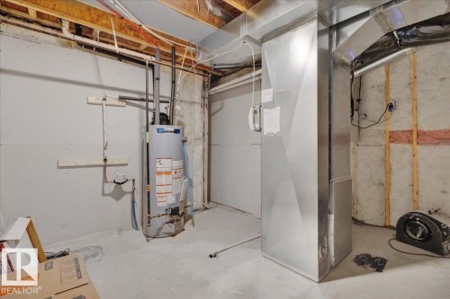 The property includes an unfinished basement with exposed ceiling joists, a water heater, and a furnace - 207 Starling, Fort Saskatchewan, AB - Indoor Photo Showing Basement