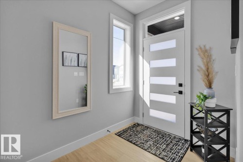Entryway featuring a modern door with horizontal privacy glass panels, a full-length window, and light-toned flooring - 207 Starling, Fort Saskatchewan, AB - Indoor Photo Showing Other Room