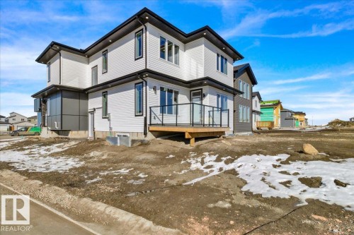 The property features a modern exterior with white siding, black trim, and a black roof - 207 Starling, Fort Saskatchewan, AB - Outdoor