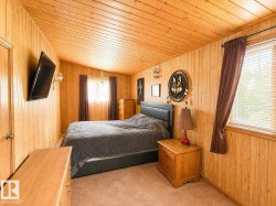 Sloped ceiling room featuring light-toned wood paneling on walls and ceiling - 