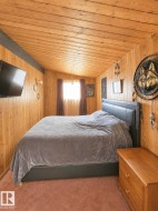 Room featuring wood-paneled walls and a matching wood-paneled sloped ceiling - 
