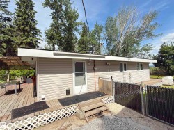 Neutral-toned siding exterior featuring a multi-level wooden deck - 