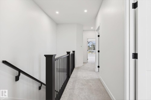 Hallway with light gray carpet, recessed lighting, and a white door with black hinges - 9705 68 Avenue, Edmonton, AB - Indoor Photo Showing Other Room