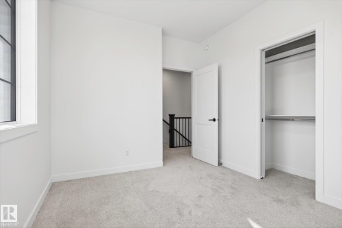 This room features light gray carpeting and white walls, offering a neutral palette - 9705 68 Avenue, Edmonton, AB - Indoor Photo Showing Other Room