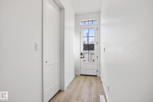 Entryway featuring light-colored wood flooring and a white door with glass panels - 9705 68 Avenue, Edmonton, AB - Indoor Photo Showing Other Room