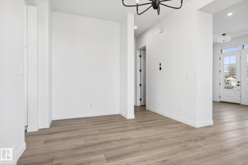 Entryway featuring light-toned flooring, white walls, and a view of the outside through a glass-paneled door - 9705 68 Avenue, Edmonton, AB - Indoor Photo Showing Other Room