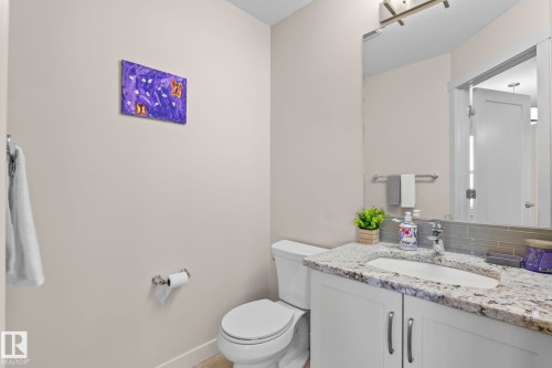 Bathroom featuring a vanity with a light-colored countertop, an undermount sink, and a large mirror - 24 4205 30 Street, Edmonton, AB - Indoor Photo Showing Bathroom