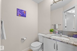 Bathroom featuring a vanity with a light-colored countertop, an undermount sink, and a large mirror - 