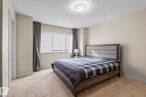 This room features carpeting, a window with blinds and drapes, and an upholstered headboard - 24 4205 30 Street, Edmonton, AB - Indoor Photo Showing Bedroom