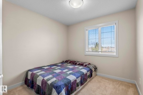 This room features light-colored walls and carpeting, a window with blinds, and an overhead light fixture - 24 4205 30 Street, Edmonton, AB - Indoor Photo Showing Bedroom