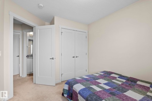 This room features neutral-toned carpet, light-colored walls, and white doors with chrome hardware - 24 4205 30 Street, Edmonton, AB - Indoor Photo Showing Bedroom