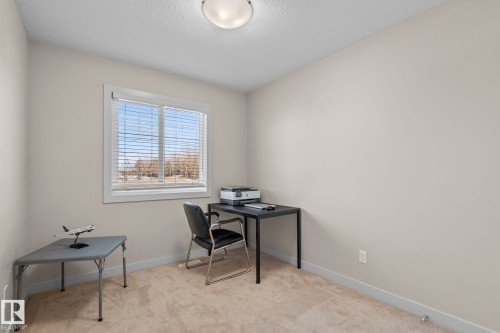 This room features a window with blinds, carpeted flooring, and neutral-toned walls - 24 4205 30 Street, Edmonton, AB - Indoor Photo Showing Office