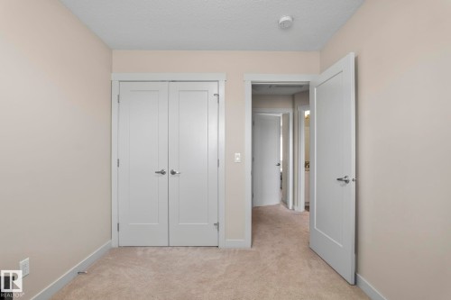 This room features neutral-toned walls, light-colored carpeting, and white trim - 24 4205 30 Street, Edmonton, AB - Indoor Photo Showing Other Room
