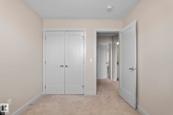 This room features neutral-toned walls, light-colored carpeting, and white trim - 
