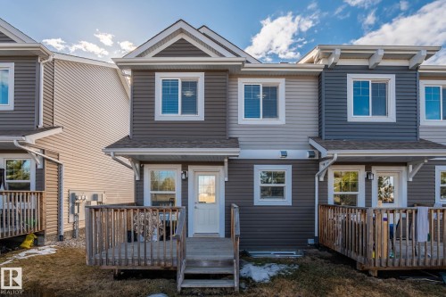 The property features an exterior with gray siding and white trim, complete with a rear deck and a well-maintained lawn area - 24 4205 30 Street, Edmonton, AB - Outdoor With Deck Patio Veranda With Facade