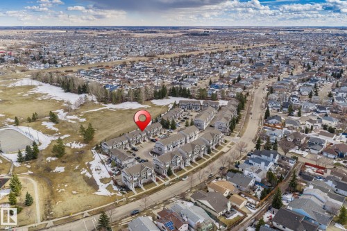 Aerial view showcasing the residential neighbourhood, with a large expanse of open land and trees visible - 24 4205 30 Street, Edmonton, AB - Outdoor With View