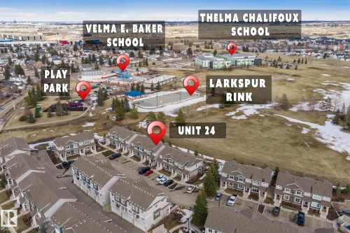Aerial view highlighting the property's location within a residential area, with nearby amenities including a play park, a rink, and two schools - 24 4205 30 Street, Edmonton, AB - Outdoor With View