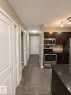 The property includes a kitchen with dark cabinetry, stainless steel appliances, and a dark countertop - 209 107, Watt Commom, Edmonton, AB 