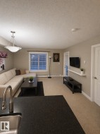 Open concept living area with carpeting, a window with blinds, and a light fixture - 