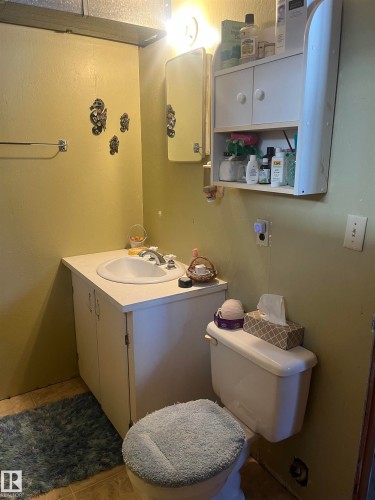 The bathroom features a vanity with a sink, a wall-mounted mirror, and a toilet - 55131 Range Road 83, Rural Yellowhead, AB - Indoor Photo Showing Bathroom