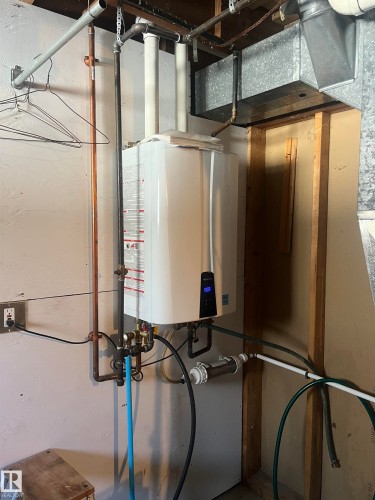 Tankless water heater with visible plumbing and ductwork - 55131 Range Road 83, Rural Yellowhead, AB - Indoor Photo Showing Basement