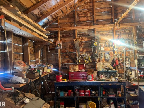 This property offers a versatile space with exposed wooden beams and plank walls, ideal for a workshop or storage - 55131 Range Road 83, Rural Yellowhead, AB - Indoor Photo Showing Basement