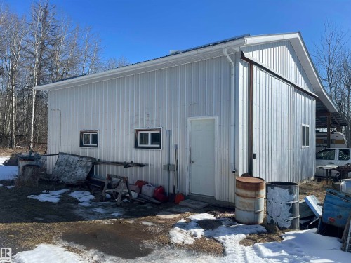 The property features a metal-sided building with white trim, a white door, and small windows - 55131 Range Road 83, Rural Yellowhead, AB - Outdoor With Exterior
