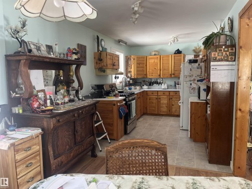 The kitchen features light wood cabinetry, white countertops, and tiled flooring - 55131 Range Road 83, Rural Yellowhead, AB - Indoor