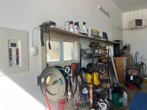 This space includes a window, a wall-mounted electrical panel, and a wall-mounted heater - 55131 Range Road 83, Rural Yellowhead, AB - Indoor Photo Showing Garage
